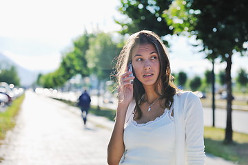 Image showing young woman talk by cellphone on street