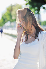 Image showing young woman talk by cellphone on street