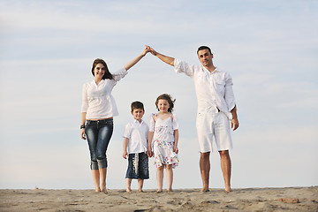 Image showing family on beach showing home sign