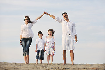 Image showing family on beach showing home sign