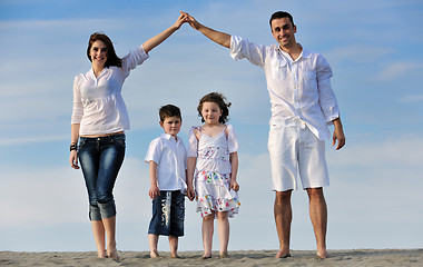 Image showing family on beach showing home sign