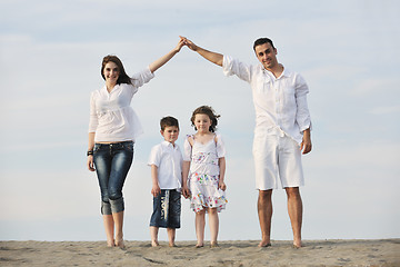 Image showing family on beach showing home sign