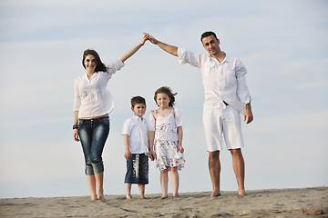 Image showing family on beach showing home sign