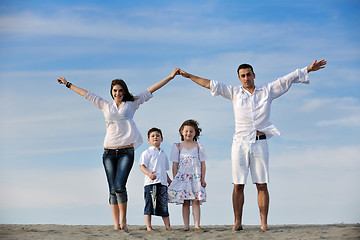 Image showing family on beach showing home sign