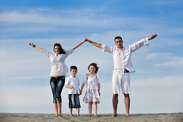 Image showing family on beach showing home sign