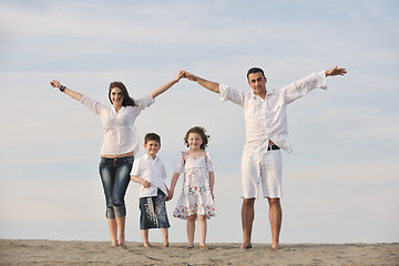 Image showing family on beach showing home sign