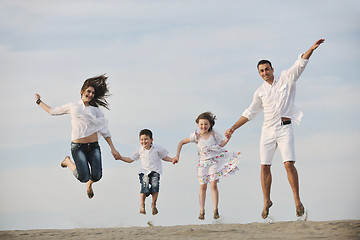 Image showing family on beach showing home sign