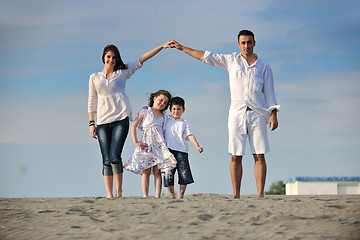 Image showing family on beach showing home sign