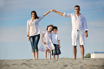 Image showing family on beach showing home sign