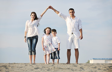 Image showing family on beach showing home sign