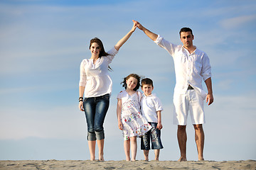 Image showing family on beach showing home sign