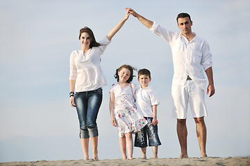 Image showing family on beach showing home sign