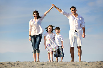 Image showing family on beach showing home sign