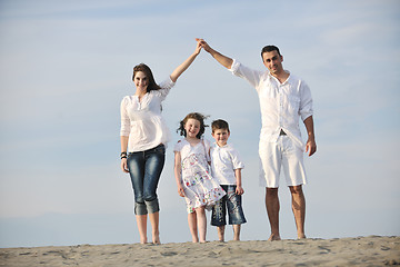 Image showing family on beach showing home sign