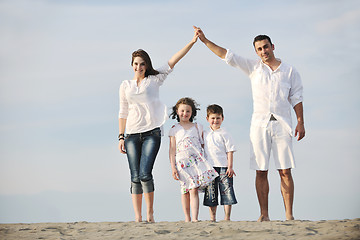 Image showing family on beach showing home sign