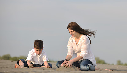 Image showing mom and son relaxing on beach