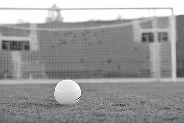 Image showing Soccer ball on grass at goal and stadium in background