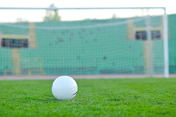 Image showing Soccer ball on grass at goal and stadium in background