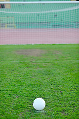 Image showing Soccer ball on grass at goal and stadium in background