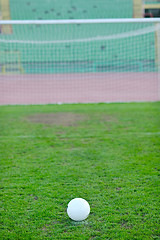 Image showing Soccer ball on grass at goal and stadium in background