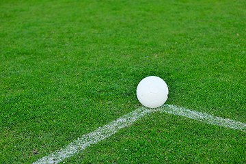 Image showing Soccer ball on grass at goal and stadium in background