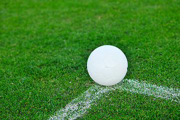 Image showing Soccer ball on grass at goal and stadium in background