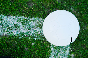 Image showing Soccer ball on grass at goal and stadium in background