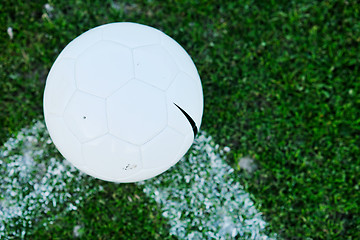 Image showing Soccer ball on grass at goal and stadium in background