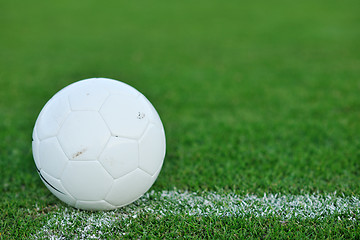 Image showing Soccer ball on grass at goal and stadium in background