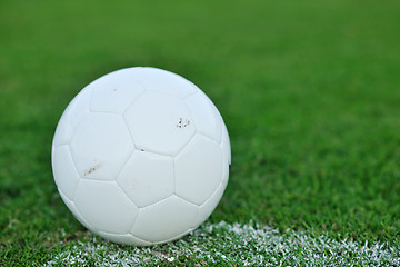 Image showing Soccer ball on grass at goal and stadium in background