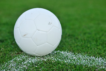 Image showing Soccer ball on grass at goal and stadium in background