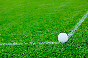 Image showing Soccer ball on grass at goal and stadium in background