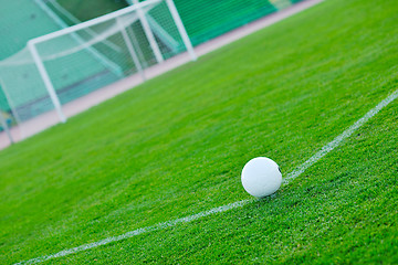 Image showing Soccer ball on grass at goal and stadium in background