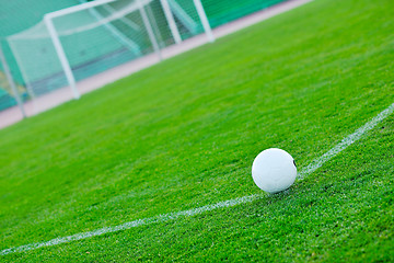 Image showing Soccer ball on grass at goal and stadium in background