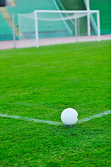 Image showing Soccer ball on grass at goal and stadium in background