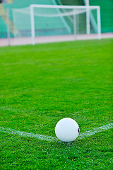 Image showing Soccer ball on grass at goal and stadium in background