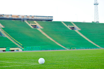 Image showing Soccer ball on grass at goal and stadium in background