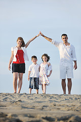 Image showing family on beach showing home sign