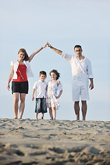 Image showing family on beach showing home sign