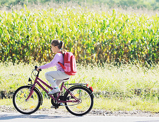 Image showing schoolgirl traveling to school on bicycle