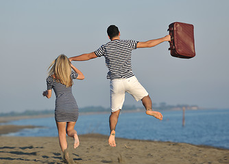 Image showing couple on beach with travel bag