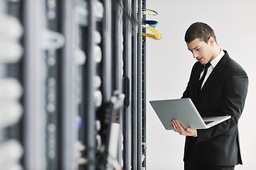 Image showing businessman with laptop in network server room