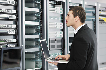 Image showing businessman with laptop in network server room