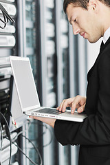 Image showing businessman with laptop in network server room