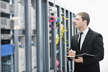 Image showing businessman with laptop in network server room