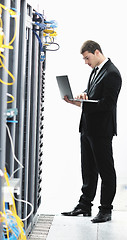 Image showing businessman with laptop in network server room