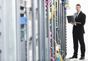 Image showing businessman with laptop in network server room