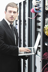 Image showing businessman with laptop in network server room