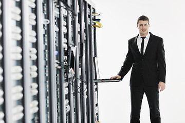 Image showing businessman with laptop in network server room