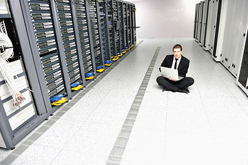 Image showing businessman with laptop in network server room